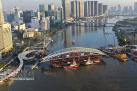Vue panoramique de la barge transportant la travée principale, mise en place pour l'achèvement du projet de passerelle piétonne enjambant la rivière Saïgon. Photo : VNA