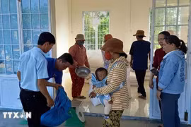 Distribuer du riz aux personnes démunies. Photo : VNA