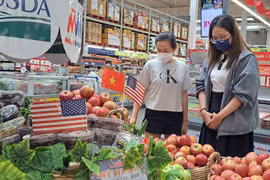 Des consommateurs choisissent des pommes américaines dans un supermarché à Hô Chi Minh-Ville. Photo : nld.com.vn