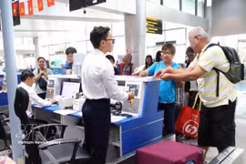 Des touristes internationaux effectuent les formalités d’enregistrement à l’aéroport international de Lien Khuong. Photo : VNA