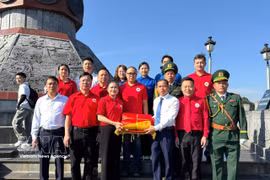 Duong Ngoc Duc, secrétaire du Comité du Parti et président du Conseil populaire de la commune de Lung Cu, remet à Do Thi Thu Thao le drapeau national ayant flotté sur le mât national de Lung Cu. Do Thi Thu Thao est membre du Présidium du Comité central du Front de la Patrie du Vietnam, présidente du Comité central de la Croix-Rouge vietnamienne, ainsi que députée à la 16e Assemblée nationale. Photo : VNA