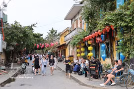 Des touristes internationaux déambulent dans les rues de Hoi An. Photo : VNA