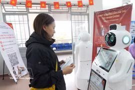 Une citoyenne interagit avec un robot doté d'intelligence artificielle pour obtenir des conseils sur les démarches administratives au centre de services administratifs publics du quartier de Xuan Huong à Da Lat (province de Lam Dong). Photo : VNA