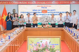 Trinh Van Quyet, membre du Bureau politique, secrétaire du Comité central du Parti et chef de la Commission centrale de la sensibilisation, de l’éducation et de la mobilisation des masses, offre des fleurs et adresse ses félicitations à l’ensemble du personnel de la VNA. Photo: VNA