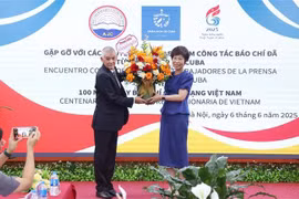 Le représentant de l'agence de presse Prensa Latina au Vietnam offert des fleurs à la directrice générale de VNA, Vu Viêt Trang à l'occasion de la Journée de la presse révolutionnaire vietnamienne. Photo : VNA