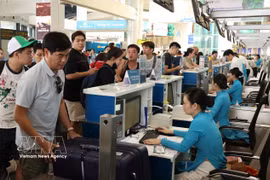 Des passagers s'enregistrent à l'aéroport de Noi Bai. Photo : VNA