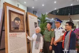 L’ancienne prisonnière politique Lê Tu Câm, émue, contemple son portrait restauré par numérisation et réalisé à partir de feuilles de lotus, exposé au Musée de Côn Dao. Photo : qdnd.vn.