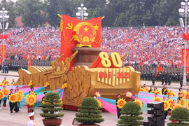 Un véhicule miniature portant l'emblème national de la République socialiste du Vietnam mène le défilé militaire et le cortège de masse. Photo : VNA