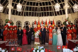 Le secrétaire général du Parti et président de la République, Tô Lâm, et son épouse, Ngô Phuong Ly, ainsi que le président suisse, Guy Parmelin, et son épouse, Caroline Parmelin, offrent des fleurs aux artistes. Photo : VNA.