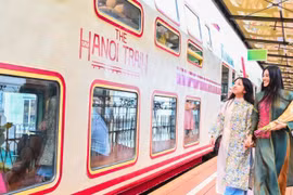 Des touristes testent le train à cinq portes, une nouvelle attraction touristique d'Hanoï. Photo : nhandan.vn