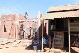 Une nouvelle maison est progressivement achevée à côté de l'ancienne maison de la famille de Ksor, un ménage pauvre du village de Mai, commune d'Ia Hrung, Gia Lai. (Photo : VNA)
