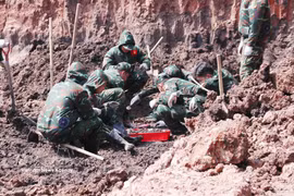 Des soldats de l’équipe K74 recherchent les restes de martyrs dans la zone B du parc Lê Thi Riêng. Photo : VNA