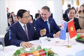 Le Premier ministre Pham Minh Chinh avec des produits de l'Institut néo-zélandais de recherche sur les plantes et les aliments. Photo : VNA