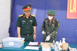 Les forces compétentes procèdent au prélèvement d'échantillons ADN au cimetière des martyrs de la commune de Y Yên, dans la province de Ninh Binh. Photo : VNA