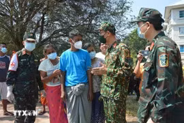 Des membres de l'Armée populaire vietnamienne discutent avec la population birmane des opérations de recherche et de sauvetage après le séisme. (Photo publiée par VNA)