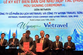 Des entreprises de voyage vietnamiennes et malaisiennes signent un accord de coopération lors de la conférence. Photo : VNA 