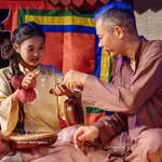 Une jeune s’initie à un instrument de musique auprès d'un artisan. Photo : VNA