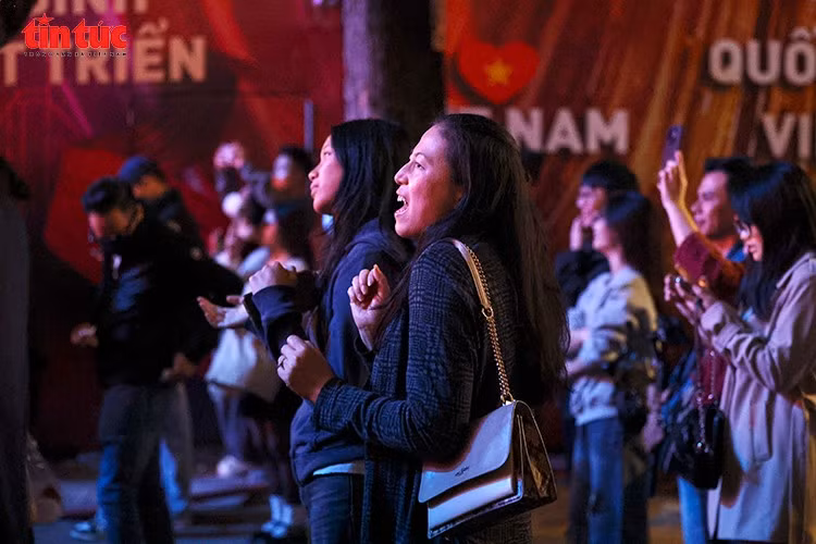 Captivés par l’événement, de nombreux touristes étrangers savourent l’atmosphère chaleureuse et les émotions partagées par le public. (Photo : Journal Tin Tuc – VNA)
