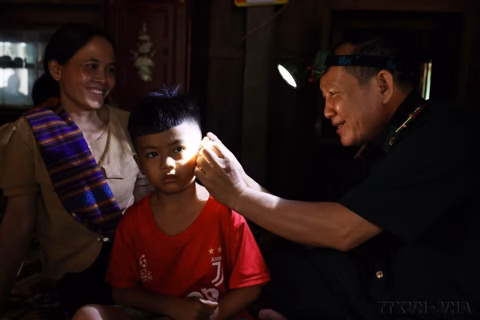 Le commandant Nguyen Hong Dung, médecin au poste frontalier de Huong Lap (Quang Tri), n’a pas hésité à braver les difficultés pour fournir des médicaments et donner des conseils sur la prévention des maladies aux habitants de l’ethnie Van Kieu vivant sur les pentes occidentales de la cordillère de Truong Son. Photo : VNA