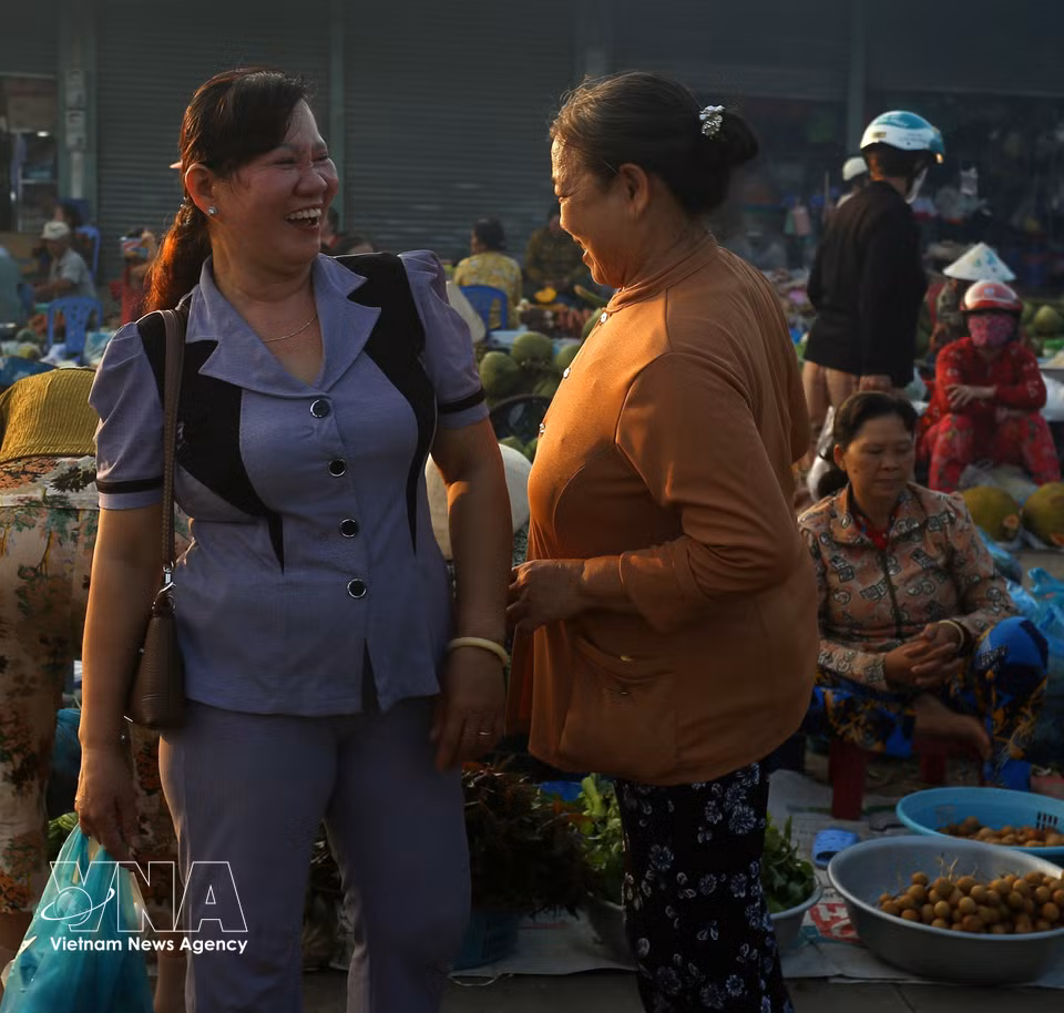 Le marché est aussi un lieu d’échanges conviviaux et de conversations animées entre acheteurs et vendeurs. Photo : VNA