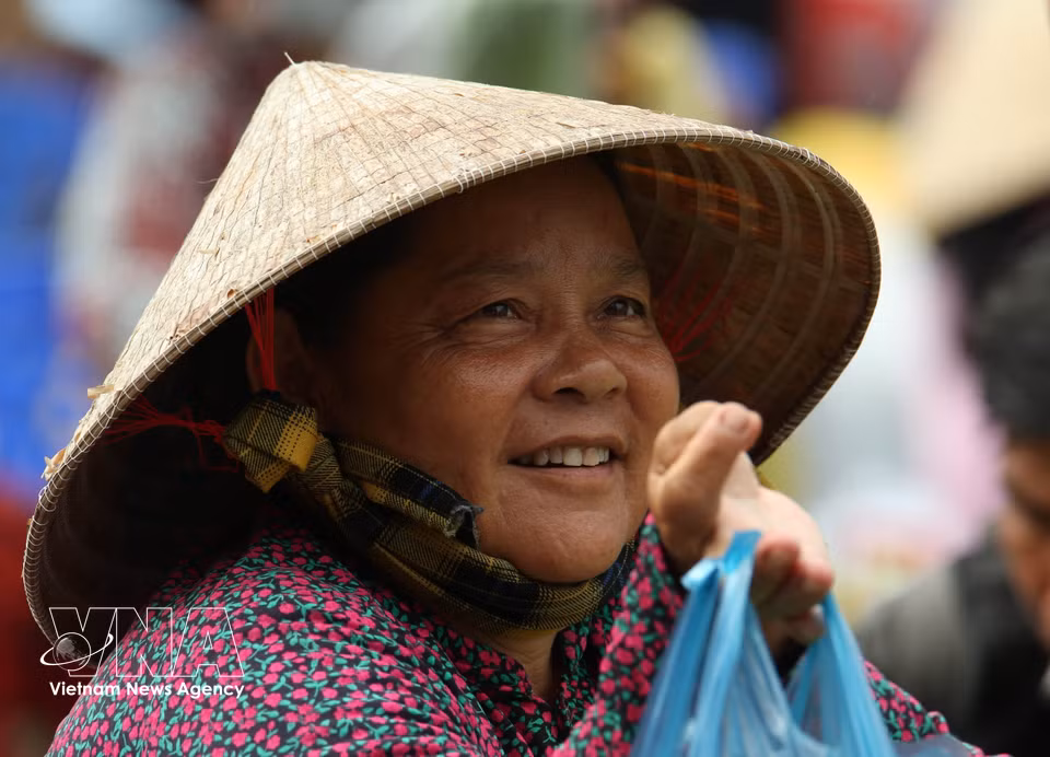 Un sourire et un regard empreints d’espoir au marché. Photo : VNA