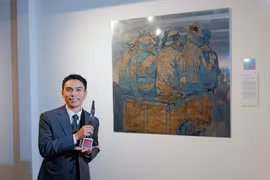 Cao Van Thuc, grand lauréat du concours Peinture de l’Année d’UOB Vietnam pour sa peinture sur laque intitulée «Gan kêt tam thoi ». Photo : nld.com.vn