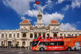 Un bus à impériale transportant des touristes passant devant le siège du Comité populaire de Hô Chi Minh-Ville. Photo: thoibaotaichinhvietnam.vn