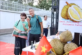 Deux touristes se font photographier avec des durians lors d'un événement vietnamien promouvant ce fruit savoureux. Photo: VNA