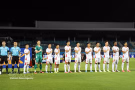 Les joueurs vietnamiens saluent le drapeau et chantent l'hymne national au stade de Chonburi en Thaïlande, avant leur rencontre face aux Est-Timorais. Photo: VNA