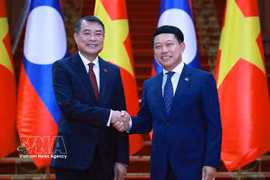 Le Premier ministre vietnamien Lê Minh Hung et le Premier ministre lao Saleumxay Kommasith se serrent la main, à Vientiane, le 8 octobre. Photo : VNA