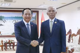 Trinh Van Quyêt (à gauche), secrétaire du Comité central du PCV et chef de sa Commission de la sensibilisation, de l’éducation et de la mobilisation des masses, et Khamphan Pheuiyavong, secrétaire du Comité central du PPRL et président de sa Commission de la propagande et de la formation, se serrent la main, à Vientiane, le 1er décembre. Photo : VNA