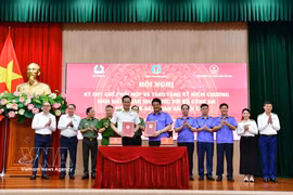 Le procureur général du Parquet populaire suprême, Nguyên Huy Tiên, et l'auditeur général Nguyên Huu Nghia échangent le règlement relatif à la coordination du travail. Photo : VNA