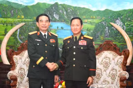 Le général Phan Van Giang (à gauche) et le général de corps d’armée Khamliang Outhakaysone se serrent la main, à Vientiane. Photo : qdnd.vn