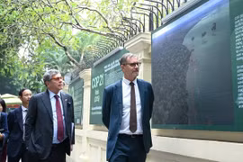 L'ambassadeur de France au Vietnam, Olivier Brochet et l'ambassadeur du Brésil au Vietnam, Marco Farani à l’exposition photographique commémorant le 10ᵉ anniversaire de l’Accord de Paris et illustrant le soutien de la France au Vietnam. Photos : nongnghiepmoitruong.vn