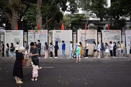 Une file de visiteurs faisant la queue pour découvrir l’exposition photographique « Éclat du nom de l’Oncle » et recevoir le supplément spécial du Journal Nhân Dân, à l’occasion du 135e anniversaire de la naissance du président Hô Chi Minh. Photo : NDEL