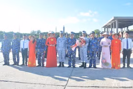 Le colonel Bui Quang Thuyên offre des fleurs au commodore Francisco C. Cacho lors de l'événement. Photo : qdnd.vn