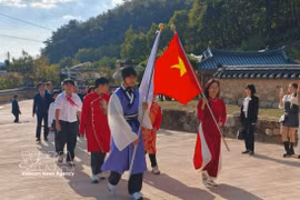 Deux drapeaux ouvraient la marche du cortège «Le Dragon qui revient» alors qu’il pénétrait dans le Trung Hiêu Duong. Photo : VNA
