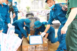 Prélèvement des échantillons sur les restes de martyrs non identifiés au cimetière des martyrs de la commune de Son Duong, dans la province de Tuyên Quang. Photo : VNA