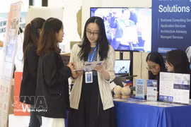 Visiteurs à une exposition sur les technologies au service du développement des infrastructures du gouvernement numérique et les technologies de paiement sans numéraire. Photo: VNA
