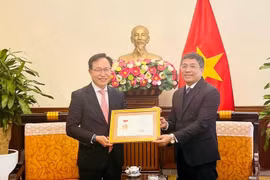 Le vice-ministre permanent des Affaires étrangères Nguyên Minh Vu (à droite) remet l’insigne «Pour la cause des affaires étrangères du Vietnam» au directeur général de Samsung Vietnam, Choi Joo Ho, à Hanoi, le 13 février. Photo : VNA