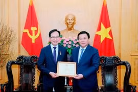 Le membre du Politburo, président de l’Académie nationale de politique Hô Chi Minh (HCMA) et président du Conseil théorique central, Nguyên Xuân Thang (à droite) décerne l'Insigne de l'HCMA «Pour la cause de l'éducation et de la formation en théorie politique» au directeur général de Samsung Vietnam, Choi Joo Ho. Photo : VNA