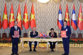 Le secrétaire général du Parti communiste du Vietnam, Tô Lâm, et le secrétaire général du Parti révolutionnaire populaire lao et président lao, Thongloun Sisoulith supervisent l’échange des accords de coopération entre les deux pays. Photo : VNA