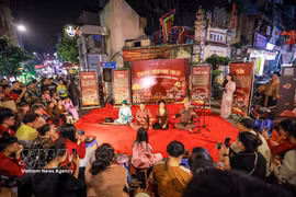 Touristes et habitants locaux vivant l’art traditionnel au cœur du vieux quartier de Hanoi. Photo: VNA