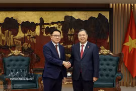 Le vice-Premier ministre permanent Pham Gia Tuc (à droite) serre la main du ministre lao de l’Agriculture et de l’Environnement, Linkham Douangsavanh, à Hanoi, le 14 juillet. Photo : VNA