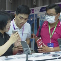 Des visiteurs s'intéressent aux produits de haute technologie. Photo: VietnamPlus