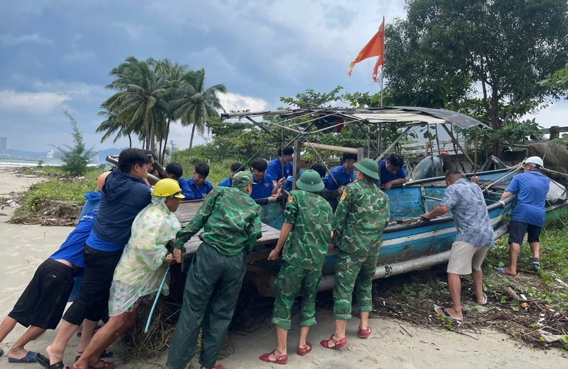 Les membres de l'Union de la jeunesse du district de Lien Chieu, à Da Nang, soutiennent les gens qui ramèneront des bateaux-paniers à terre en octobre 2024. Photo : VNA