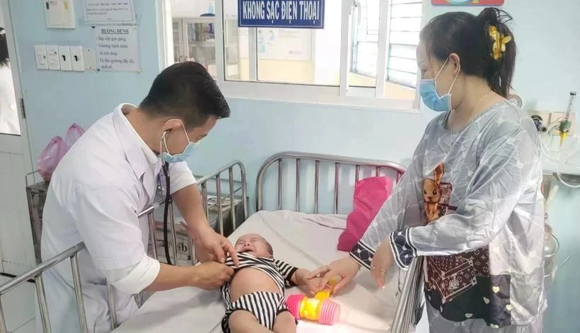 Un médecin de l'hôpital pour enfants No1 de Ho Chi Minh-Ville examine un enfant atteint de rougeole. (Photo : VNA)