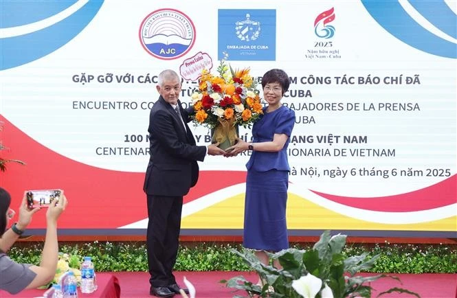 Le représentant de l'agence de presse Prensa Latina au Vietnam offert des fleurs à la directrice générale de VNA, Vu Viêt Trang à l'occasion de la Journée de la presse révolutionnaire vietnamienne. Photo : VNA