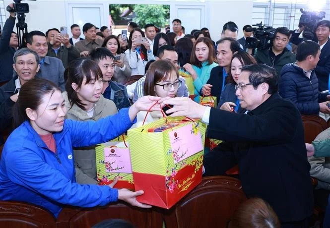 Le Premier ministre Pham Minh Chinh offre des cadeaux aux ouvriers au district de Ngoc Lac, dans la province de Thanh Hoa. Photo: VNA