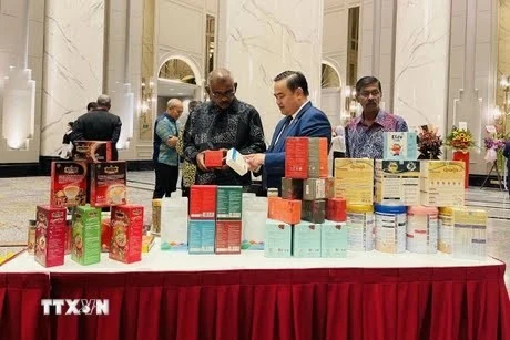 Le Phu Cuong (au milieu), conseiller commercial vietnamien en Malaisie, présente des produits vietnamiens lors d'une foire en Malaisie. Photo : VNA